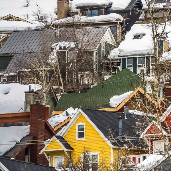 Τετράγωνη κορνίζα σπίτια με πολύχρωμους εξωτερικούς τοίχους χτισμένο στο βουνό με παχύ χιόνι το χειμώνα — Φωτογραφία Αρχείου