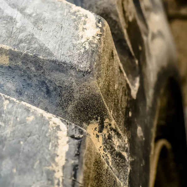 Fyrkantig ram närbild av smutsiga svarta gummi däck av en tung konstruktion fordon — Stockfoto