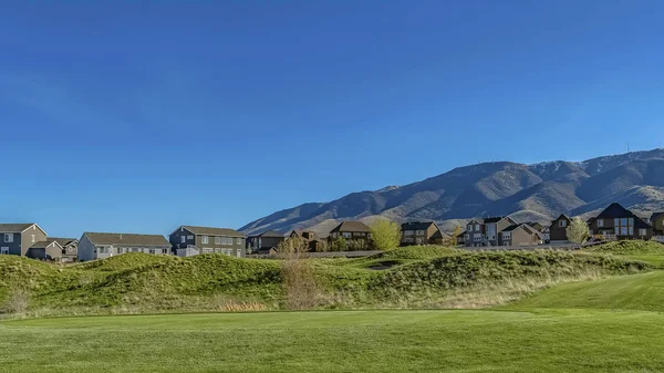 Panorama Yemyeşil otlarla kaplı geniş bir çimenli arazi üzerinde dar asfalt yol