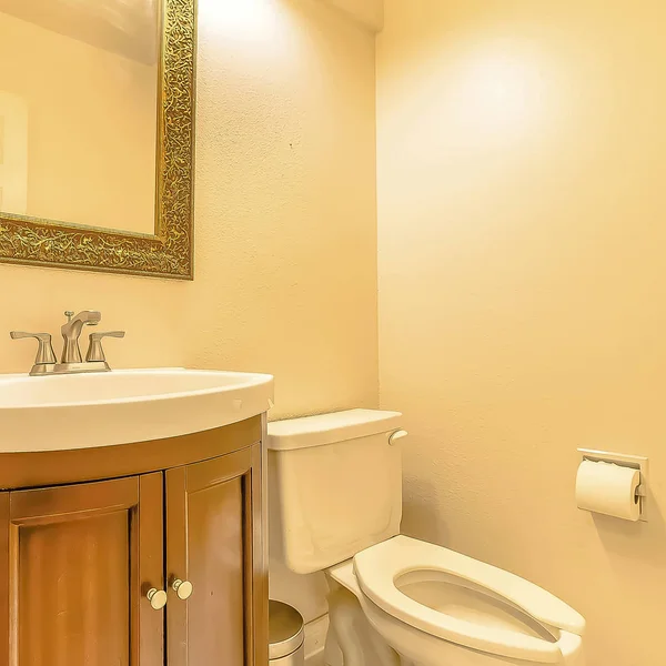 Toalett och handfat inuti badrum i ett hus med grädde färgad vägg — Stockfoto