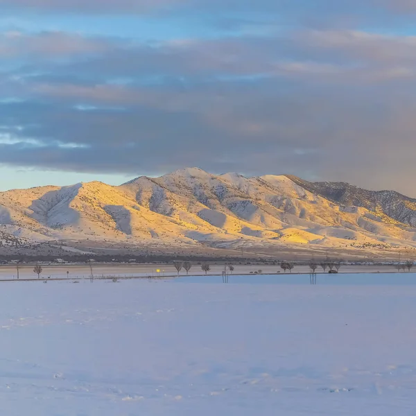 Vaste terrain et montagne imposante couverte de neige par une froide journée d'hiver — Photo