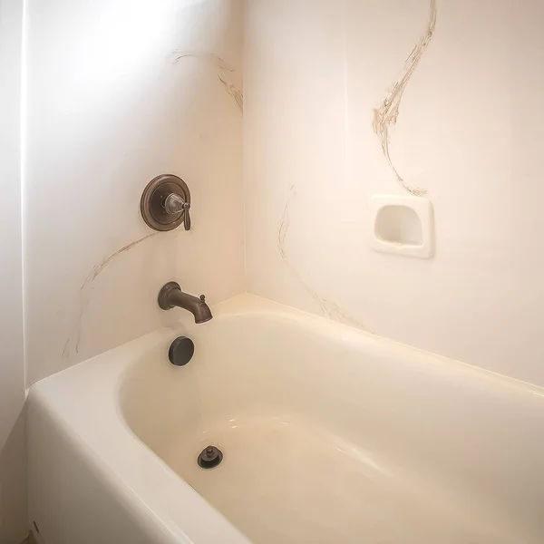 Kwadratowa błyszcząca wanna i prysznic wewnątrz łazienki domu z białą ścianą — Zdjęcie stockowe
