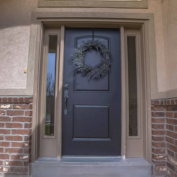 Square frame Wreath and doormat on the front door with sidelights and transom window