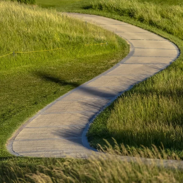 Quadrado Pathway que ventos através de um terreno gramado com casas no fundo — Fotografia de Stock