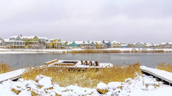 Marco panorámico Lago rodeado de nieve cubierta de tierra y bajo cielo nublado en invierno — Foto de Stock