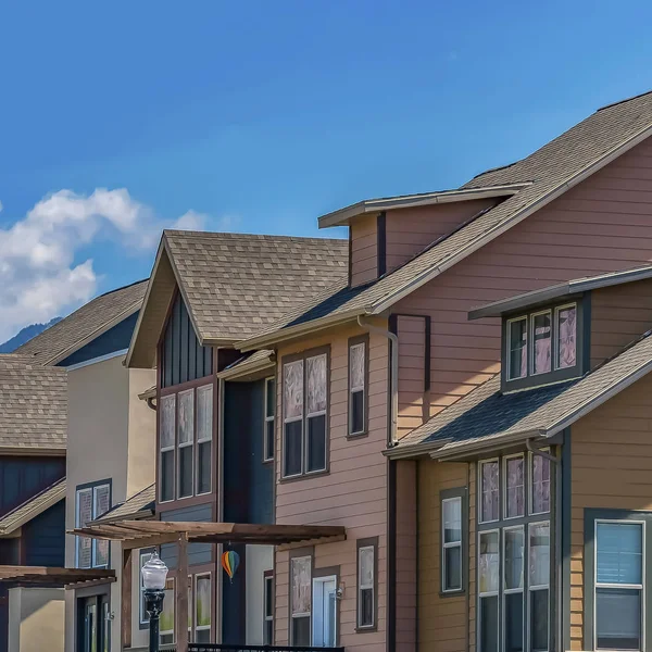 Fila de viviendas con porches y balcón contra montaña y cielo en un día soleado — Foto de Stock