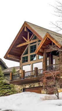 Dikey çerçeve Bulutlu bir kış gününde taze kar ortasında güzel bir ahşap evin dış