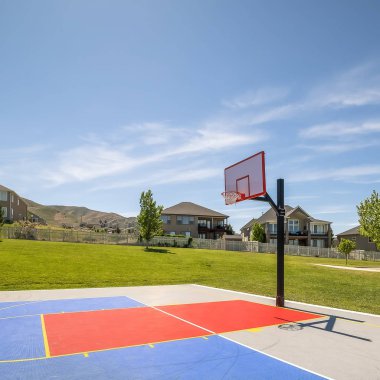 Ev dağ ve mavi gökyüzü arka plan ile Square Outdoor kamu basketbol sahası