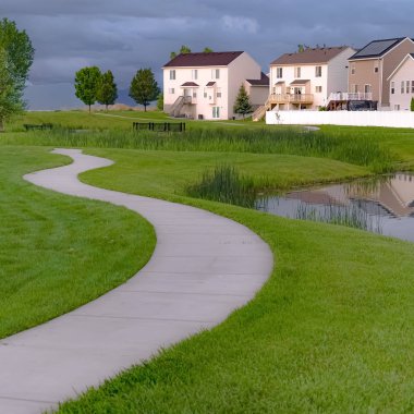 Açık merdiven ve balkonlu evlerin önünde köprülü kare çerçeveLi Geçit ve gölet