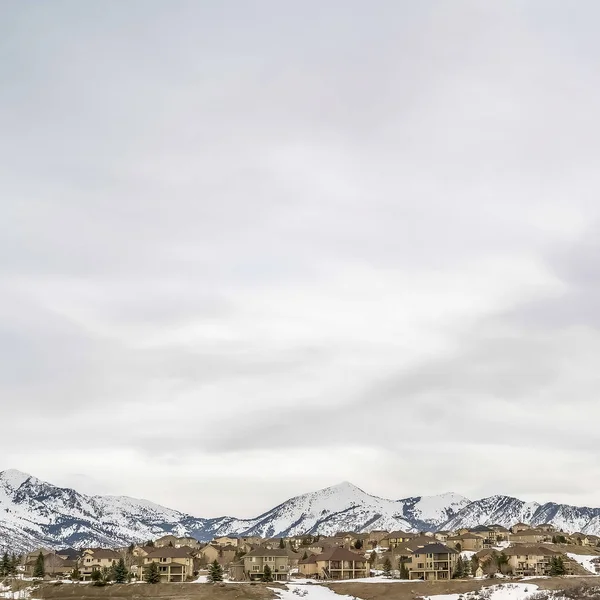 Marco cuadrado Panorama de zona residencial y carretera en una colina contra el cielo nublado en invierno —  Fotos de Stock