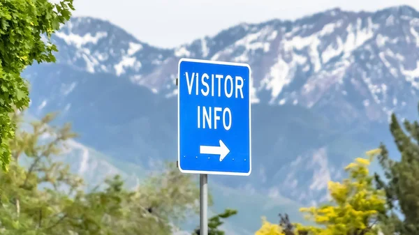 Panorama Cierre de un cartel de información para visitantes con árboles nevados de montaña y fondo de cielo — Foto de Stock