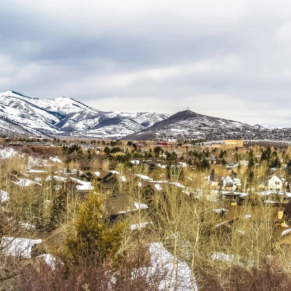 Place Vue panoramique des maisons et majestueuse montagne contre ciel nuageux en hiver — Photo