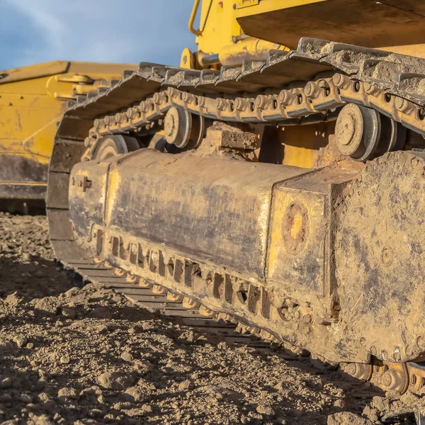 Excavadora cuadrada amarilla con vista de cerca del marco de la pista de la almohadilla del grouser y rodillos — Foto de Stock