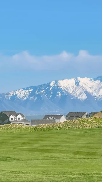 Vertikale Wohngegend mit Blick auf einen See und schneebedeckten Berg unter blauem Himmel — Stockfoto