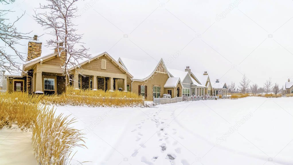 Panorama frame Scenic winter view of snow covered ground in front of houses under cloudy sky