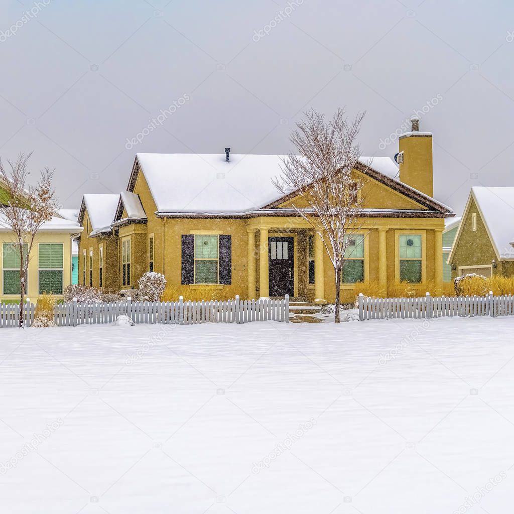 Square frame Facade of beautiful houses with roofs covered with snow during winter season