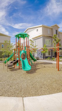 Dikey çerçeve Oyun alanı bulutlu mavi gökyüzü altında dairesel bir yol ve banklar ile çevrili