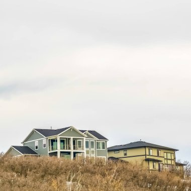 Kışın karla kaplı dağda çok katlı ev üzerinde Square Parlak bulutlu gökyüzü