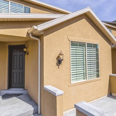 Kahverengi ön kapıya giden beton merdivenli bir eve giriş