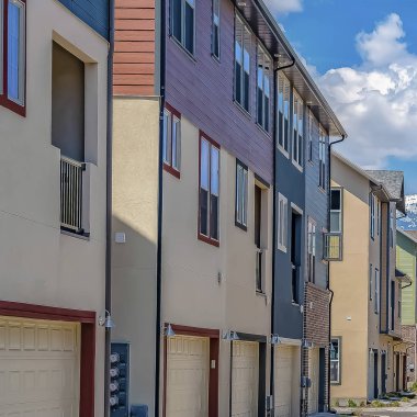 Kar kaplı dağ ve bulutlu gökyüzü manzaralı evlerin ortasında Kare çerçeve Yol