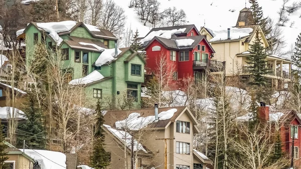 Panoramatický rám domy postavené na svahu hory, zahalené sněhem v zimě — Stock fotografie