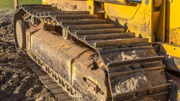 Panorama ram Dirty metal Track pad av en gul entreprenadmaskiner på en solig dag. — Stockfoto