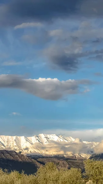 Verticale Vista panoramica sulla natura con maestosa montagna innevata sotto il cielo blu nuvoloso — Foto Stock