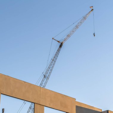 Metal vinç ve mavi gökyüzü arka plan ile yapım aşamasında Kare Bina