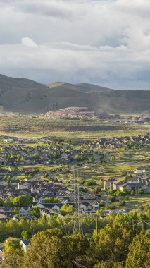 Uzak dağ ve bulutlu mavi gökyüzü manzaralı bir vadi üzerinde Dikey çerçeve Yerleşim alanı