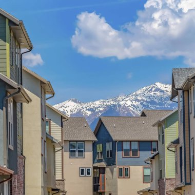 Güneşli bir günde bulutlu mavi gökyüzü altında çok katlı evlerin ortasında Yol