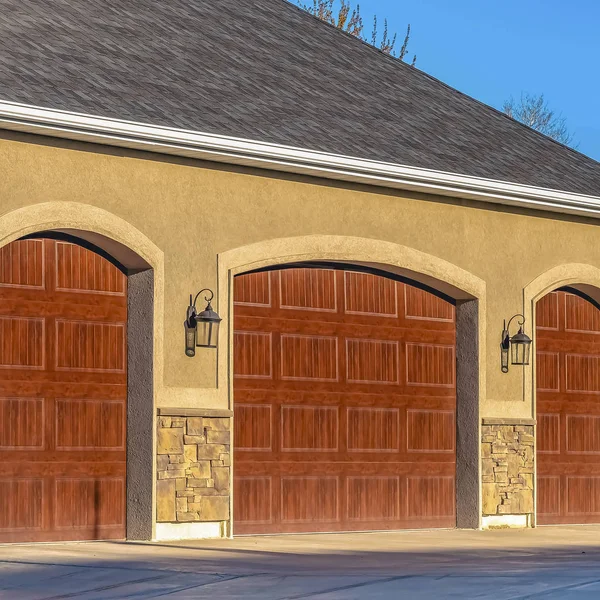 Casa cuadrada exterior con puertas de garaje de madera marrón contra el cielo azul en un día soleado — Foto de Stock