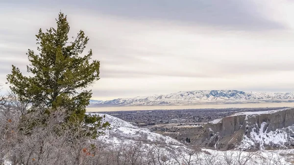 Marco panorámico Montaña cubierta de nieve con vistas a un valle bajo el cielo nublado en invierno —  Fotos de Stock