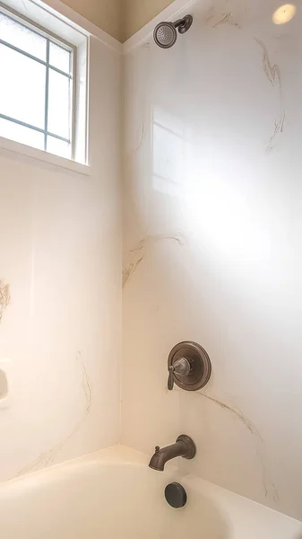Ramka pionowa błyszcząca wanna i prysznic wewnątrz łazienki domu z białą ścianą — Zdjęcie stockowe