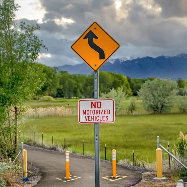 Square Winding Road Ahead and No Motorized Vehicles sign against nature background — Stock Photo, Image