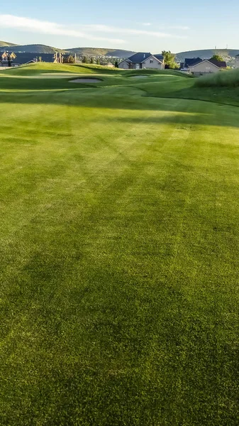 Вертикальный фарватер и боссы поля для гольфа с домами и горой вдали — стоковое фото