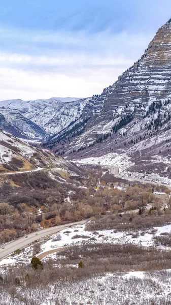 垂直道路在高耸的山间弯曲，斜坡被新鲜的雪覆盖 — 图库照片
