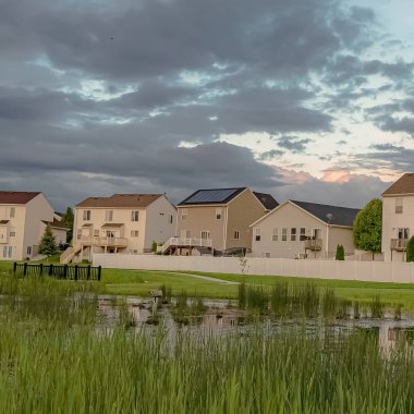 balkonlu evler çerçeve ve çimenli gölet köprü ve geniş yeşil alan manzaralı