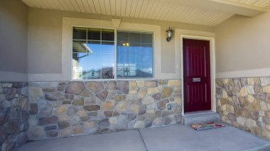 Maroon ön kapı ve beton ve taş duvar kombinasyonu ile Panorama Home cephe