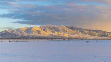 Panorama çerçeve Soğuk bir kış gününde karla kaplı engin arazi ve yükselen dağ