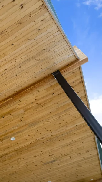 Cadre vertical Vue rapprochée de la face inférieure du toit d'une maison avec fond bleu ciel — Photo