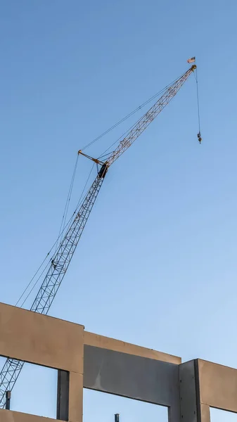 Vertikal ram oavslutad byggnad exteriör och konstruktion kran med blå himmel bakgrund — Stockfoto