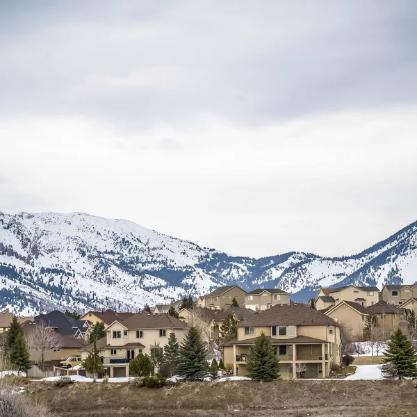 Plac utwardzonej drodze wijąca przez Snowy wzgórzu z wielopoziomowe domy w oddali — Zdjęcie stockowe