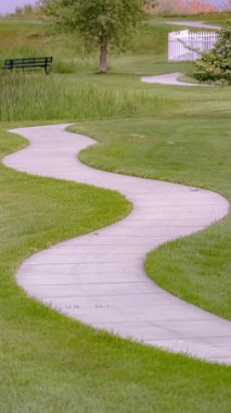 Dikey çerçeve Arka planda bir gölet ve tezgah ile çimenli arazi ile eğri