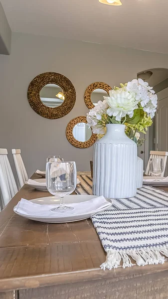 Vertical frame Dining room interior with brown wooden table and white wooden chairs