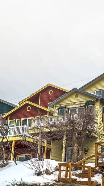 Marco vertical Casas con balcones porches y escaleras al aire libre bajo cielo gris nublado en invierno — Foto de Stock