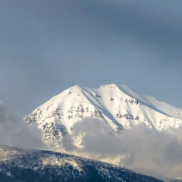 Vierkant prachtig uitzicht op een berg met zijn piek bedekt met zonovergoten witte sneeuw — Stockfoto