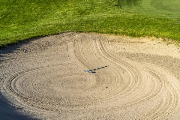 Close up de campo de golfe bunker de areia com um padrão circular criado pelo ancinho — Fotografia de Stock