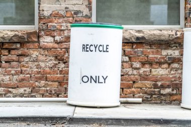 Bir çöp tenekesinin taş tuğla duvar ve pencerelere kapatılması