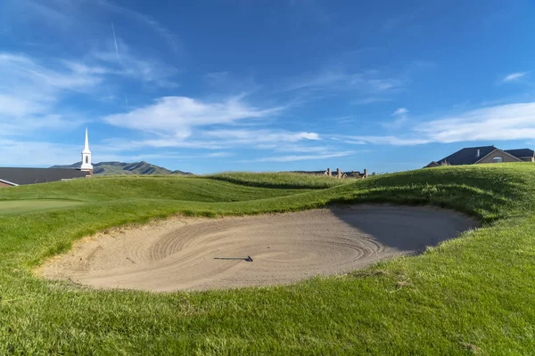 Golfplatz mit Sandbunker und lebendigem Fairway unter blauem Himmel an einem sonnigen Tag — Stockfoto