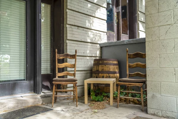 Concrete porch of a home with wooden chairs square table and barrel — Stock Photo, Image